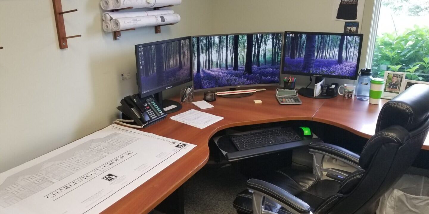 Corner office workspace with three monitors